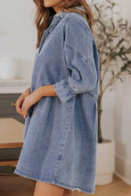 A light-wash denim dress with distressed collared neck, relaxed fit, button-up front, and elasticized cuffs