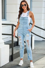 Light blue cropped distressed denim overalls with frayed hems and pockets