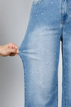 Light-wash denim tummy control raw hem jeans with subtle stitched dot pattern and distressed detail