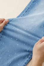 Light-wash blue denim tummy control raw hem jeans with subtle white stitching and distressed detail for slim fit