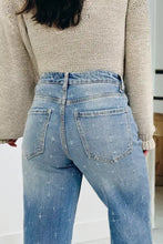 Light-wash denim tummy control raw hem jeans with subtle distressed pattern and classic back pockets shown from back