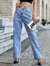 Light-wash distressed high waist jeans with a wide-leg cut and intentional rips at the knees in denim material