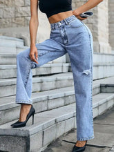 Light-wash denim distressed high waist jeans with high-rise straight-leg fit and a knee tear detailing