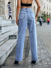 Back view of distressed high waist light blue denim jeans with straight leg cut and classic back pockets
