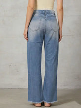 Light-wash denim bootcut jeans with frayed raw hems offering versatile pairing advice for casual styles