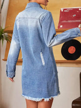 Denim mini dress with faded blue wash raw hem and distressed details including frayed edges and ripped back patch