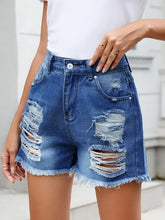 Distressed raw hem denim shorts in slightly stretchy blue denim