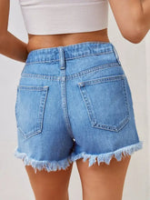 Light blue distressed raw hem denim shorts with frayed hems