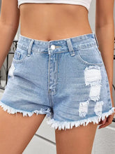 Light wash distressed raw hem denim shorts with frayed hems