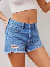 Light wash distressed raw hem denim shorts with frayed hems