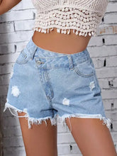 Distressed raw hem denim shorts with asymmetrical button and frayed hems