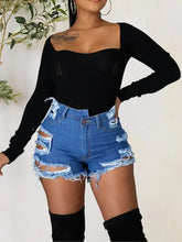 Women’s black long sleeve top with raw hem denim shorts