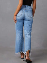 Light-wash denim flare jeans with a high-rise fit and distressed raw hem detail for a stylish casual look