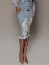 Light-wash denim skirt with raw hem and distressed slit denim detailing along the sides for a stylish look
