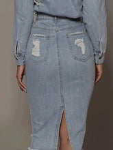 Light-wash denim skirt with distressed back pockets and a front slit featuring raw hem detailing
