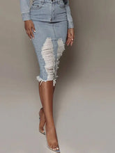 Light-wash distressed slit denim skirt with ripped detailing along thighs and raw hem for a casual look