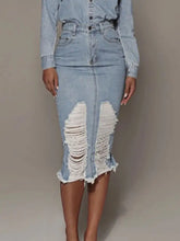 Light-wash denim skirt with distressed slit and raw hem featuring frayed patches for a casual look