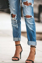 Blue denim distressed straight leg jeans with frayed holes and rolled cuffs in a straight leg fit