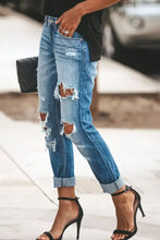 Blue denim distressed straight leg jeans featuring ripped knees and frayed edges for a casual look