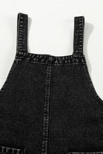Distressed wide strap denim overalls with cropped legs, adjustable straps, and pockets