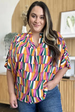 A vibrant double take full size geometric notched dolman sleeve top with bold orange green pink patterns ideal for jeans size