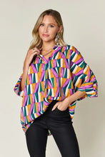 A vibrant double take full size geometric notched dolman sleeve blouse in purple orange green and white ideal for jeans size