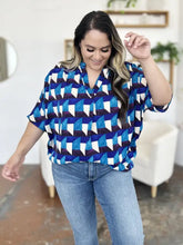 Blue and white geometric patterned double take short-sleeve blouse with v-neckline and notched half sleeves