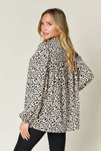 A flowing long-sleeved blouse in black and cream leopard print featuring full size design perfect for stylish occasions