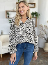A women’s long-sleeved blouse with black and white leopard print v-neckline and puffed sleeves from Double Take