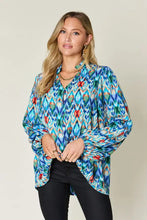 Double take full size printed balloon sleeve blouse featuring vibrant blue green and red geometric patterns with long sleeves