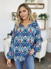 A vibrant blue green and red geometric printed balloon sleeve blouse with long flutter sleeves for stylish wear