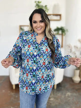 Vibrant blue green and red geometric patterned long sleeve button up blouse with balloon sleeves and v neckline
