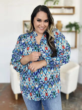 Vibrant blue red and teal ikat patterned balloon sleeve blouse with ruffled cuffs and full button-up front