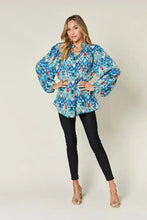 A vibrant blue green and red geometric patterned double take full size printed balloon sleeve blouse with puffed sleeves