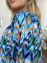 Double Take full size printed balloon sleeve blouse in vibrant blue green and red ikat pattern with flowing sheer fabric