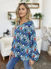 A vibrant blue red and green ikat patterned double take full size printed balloon sleeve blouse with long flared sleeves