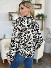 Black and white floral printed blouse with ruffle trim and balloon sleeves paired with jeans size fit guidance
