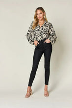 Black high-waisted skinny jeans with sleek form-fitting design paired with double take full size printed ruffle trim balloon sleeve shirt jeans size available
