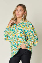 A vibrant double take full size printed smocked long sleeve blouse with bold teal yellow and cream abstract waves