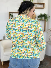 A vibrant double take full size printed smocked long sleeve blouse with bold teal yellow orange and white geometric waves