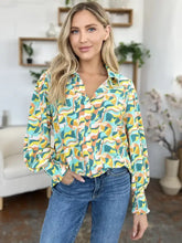 A vibrant double take full size printed smocked long sleeve blouse with bold teal yellow and orange abstract waves and ruffled cuffs