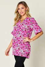 A vibrant pink floral print double take full size blouse with short flutter sleeves and v-neckline
