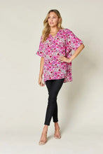 A vibrant pink and white floral print double take full size tunic with a v-neck and short flutter sleeves