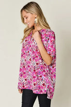 A vibrant pink and white floral print full size v-neck tunic with short sleeves perfect for casual wear