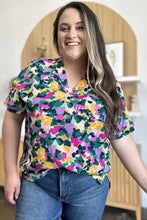 Vibrant multicolored floral print full size v-neck short sleeve top with side slit ideal for jeans size styling