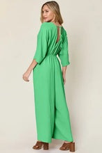 Vibrant royal blue surplice wide leg jumpsuit with cinched waist and pockets