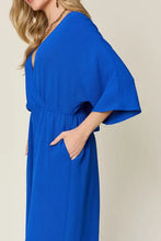 Vibrant royal blue surplice wide leg jumpsuit with v-neck and bell sleeves