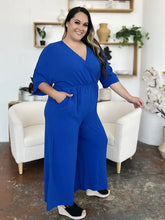 Vibrant royal blue surplice wide leg jumpsuit with v-neck and pockets
