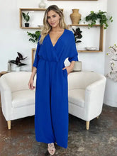 Vibrant royal blue surplice wide leg jumpsuit with v-neck and pockets