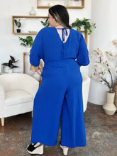 Vibrant royal blue surplice wide leg jumpsuit with back tie and pockets